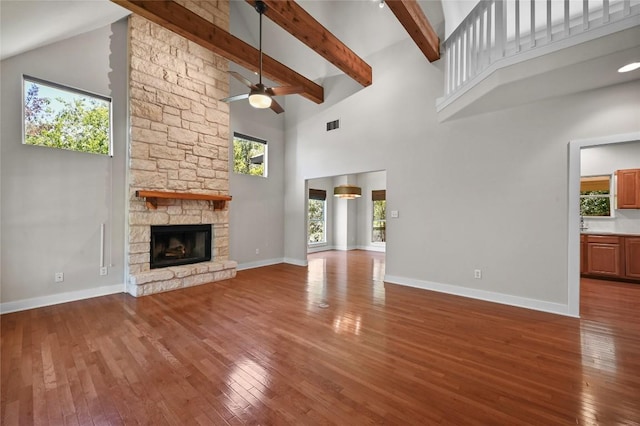 1502 Medio Calle, Austin, TX 78733 - unfurnished living room featuring high vaulted ceiling, ceiling fan, hardwood / wood-style floors, a fireplace, and beam ceiling