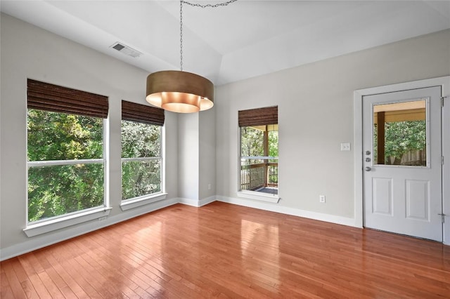 1502 Medio Calle, Austin, TX 78733 - unfurnished dining area featuring wood-type flooring and baseboards