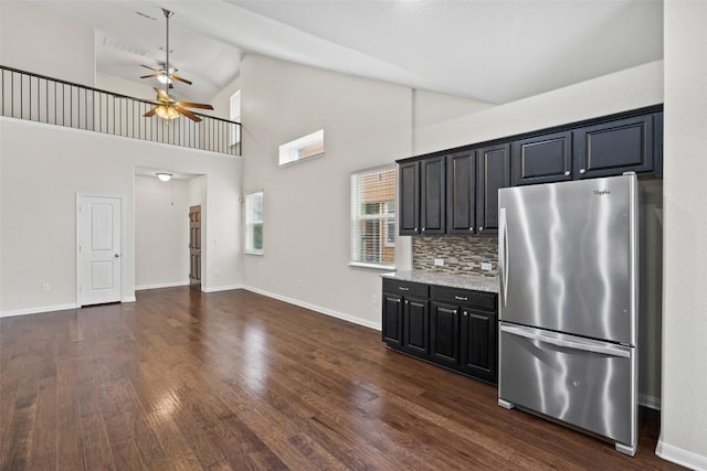 711 Rolling Oak Dr Unit 106, Round Rock, TX 78664 - kitchen featuring freestanding refrigerator, a ceiling fan, dark wood-style floors, decorative backsplash, and high vaulted ceiling