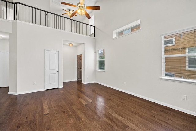 711 Rolling Oak Dr Unit 106, Round Rock, TX 78664 - empty room featuring a ceiling fan, wood finished floors, a towering ceiling, and baseboards