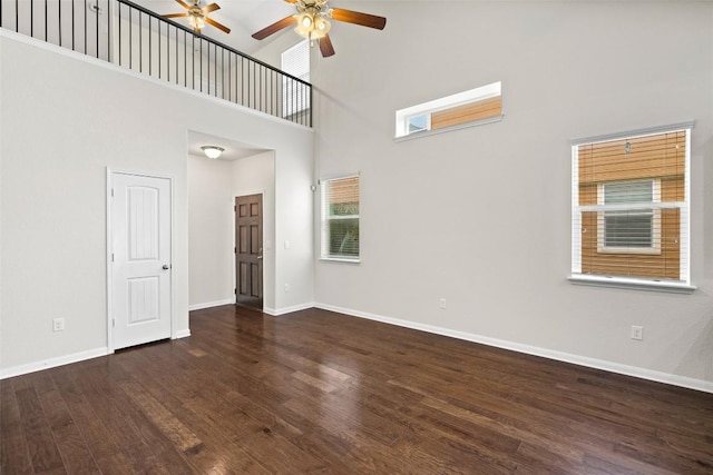 711 Rolling Oak Dr Unit 106, Round Rock, TX 78664 - spare room featuring a ceiling fan, wood finished floors, a towering ceiling, and baseboards