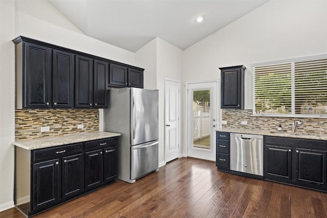 711 Rolling Oak Dr Unit 106, Round Rock, TX 78664 - kitchen with stainless steel appliances, a sink, dark cabinets, dark wood-type flooring, and tasteful backsplash