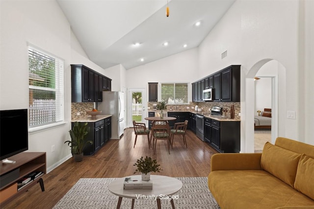 711 Rolling Oak Dr Unit 106, Round Rock, TX 78664 - kitchen with stainless steel appliances, backsplash, dark cabinets, light countertops, and open floor plan