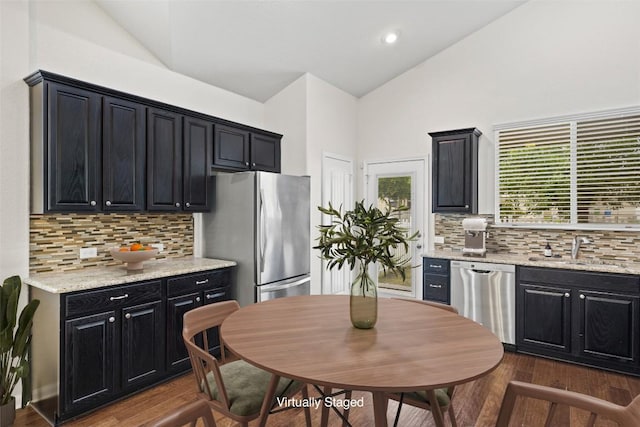 711 Rolling Oak Dr Unit 106, Round Rock, TX 78664 - kitchen featuring stainless steel appliances, a sink, dark cabinets, dark wood finished floors, and high vaulted ceiling