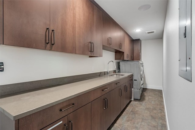 2502 Spring Creek Dr, Austin, TX 78704 - kitchen with independent washer and dryer, baseboards, a sink, light countertops, and stone finish floors