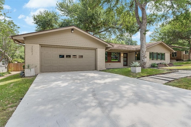 2502 Spring Creek Dr, Austin, TX 78704 - single story home with brick siding, an attached garage, and driveway