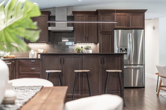 2502 Spring Creek Dr, Austin, TX 78704 - kitchen with stainless steel fridge, wall chimney exhaust hood, tasteful backsplash, dark wood-style flooring, and recessed lighting
