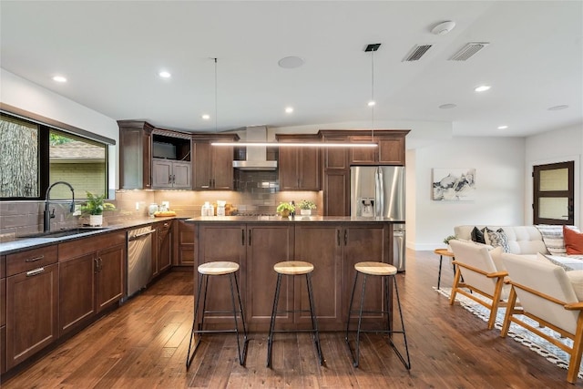 2502 Spring Creek Dr, Austin, TX 78704 - kitchen with appliances with stainless steel finishes, a center island, backsplash, dark wood-style floors, and recessed lighting