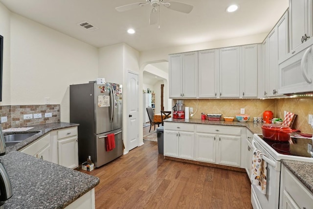 900 Lily Pad, Leander, TX 78641 - kitchen with white appliances, arched walkways, ceiling fan, decorative backsplash, and recessed lighting