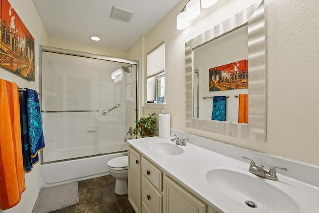 900 Lily Pad, Leander, TX 78641 - bathroom with toilet, double vanity, shower / bath combination with glass door, and stone finish flooring