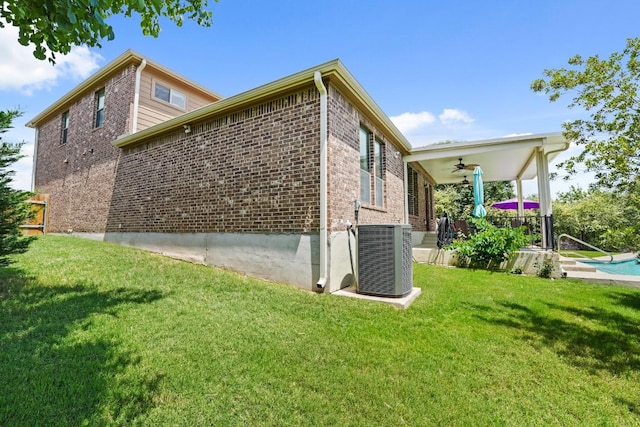 900 Lily Pad, Leander, TX 78641 - view of side of home with ceiling fan, central air condition unit, brick siding, a lawn, and an outdoor pool
