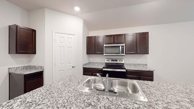 1309 Piedmont St, Temple, TX 76504 - kitchen featuring stainless steel appliances, a sink, dark brown cabinetry, recessed lighting, and vaulted ceiling