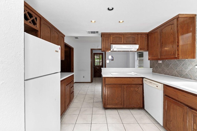 2305 Preston Trails Cv, Austin, TX 78747 - kitchen with white appliances, light tile patterned floors, decorative backsplash, a peninsula, and light countertops
