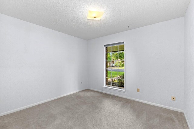 2305 Preston Trails Cv, Austin, TX 78747 - empty room with carpet floors, baseboards, and a textured ceiling