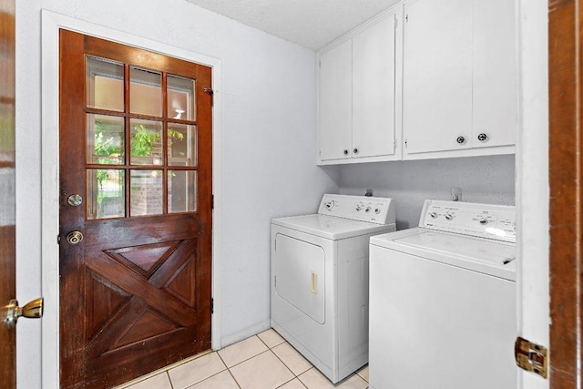 2305 Preston Trails Cv, Austin, TX 78747 - laundry room with cabinet space, washing machine and clothes dryer, light tile patterned floors, and a textured ceiling