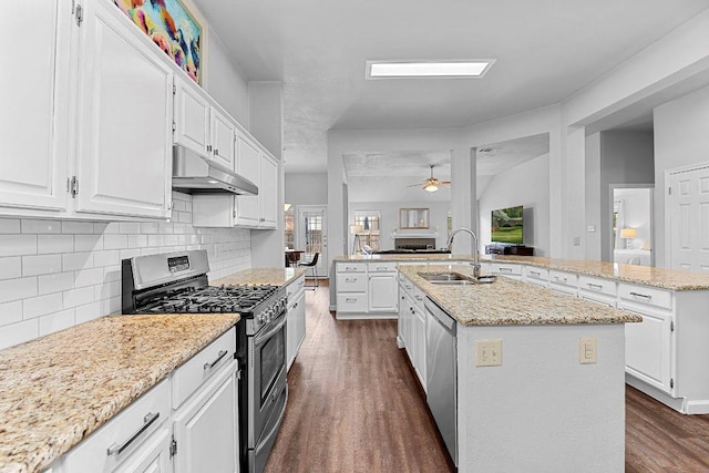 1111 Pebble Brook Rd, Cedar Park, TX 78613 - kitchen with appliances with stainless steel finishes, under cabinet range hood, a center island with sink, open floor plan, and dark wood-type flooring