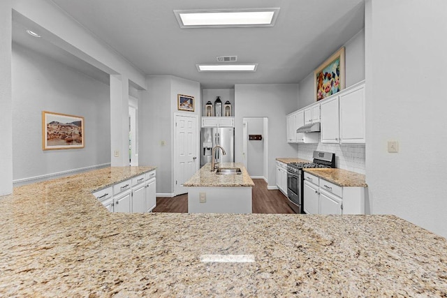 1111 Pebble Brook Rd, Cedar Park, TX 78613 - kitchen featuring appliances with stainless steel finishes, under cabinet range hood, light stone countertops, white cabinets, and dark wood-style floors