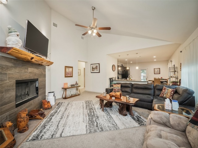 116 Naalehu Ct, Bastrop, TX 78602 - living room featuring a tile fireplace, ceiling fan, high vaulted ceiling, and carpet floors