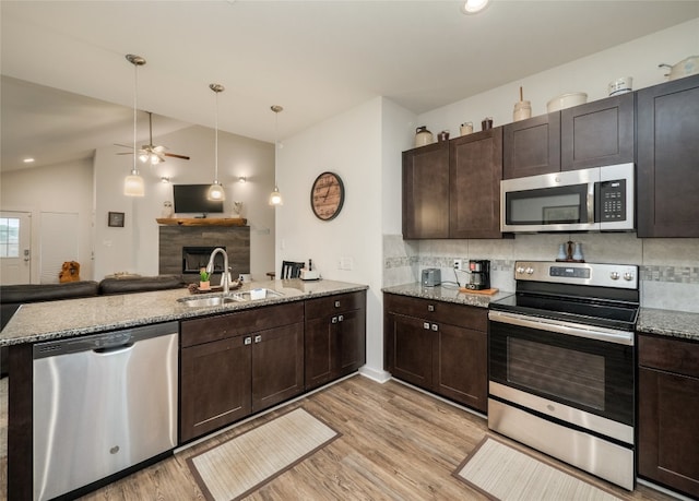 116 Naalehu Ct, Bastrop, TX 78602 - kitchen featuring appliances with stainless steel finishes, a sink, lofted ceiling, a ceiling fan, and decorative backsplash