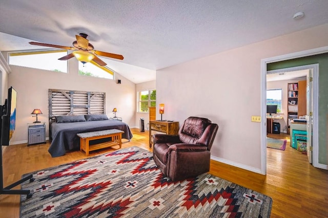 1231 Montell Rd, Wimberley, TX 78676 - bedroom with wood finished floors, vaulted ceiling, baseboards, a textured ceiling, and a ceiling fan