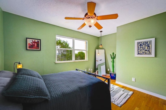 1231 Montell Rd, Wimberley, TX 78676 - bedroom with wood finished floors, baseboards, and ceiling fan