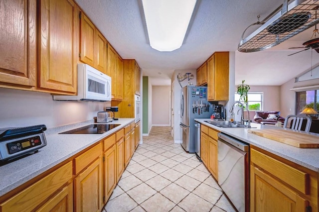 1231 Montell Rd, Wimberley, TX 78676 - kitchen with appliances with stainless steel finishes, a sink, ceiling fan, light countertops, and light tile patterned floors