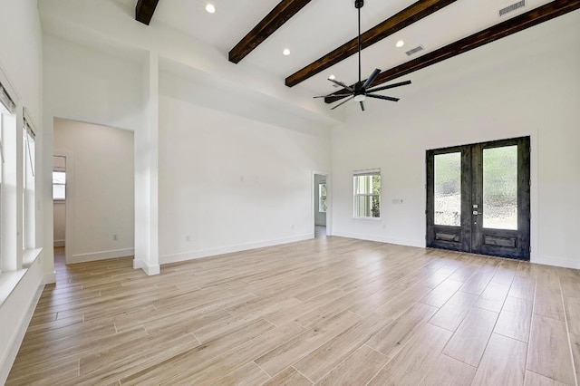 2803 Wilson Ave, Lago Vista, TX 78645 - unfurnished living room with french doors, a ceiling fan, beamed ceiling, a towering ceiling, and light wood-style flooring