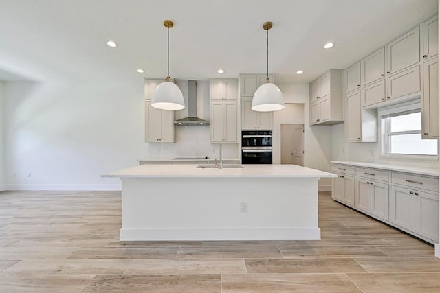 2803 Wilson Ave, Lago Vista, TX 78645 - kitchen featuring wall chimney range hood, black appliances, recessed lighting, light countertops, and a center island with sink