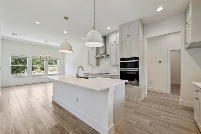 2803 Wilson Ave, Lago Vista, TX 78645 - kitchen with wall chimney range hood, recessed lighting, black electric stovetop, a chandelier, and light wood-type flooring