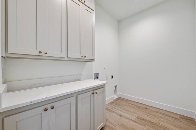 2803 Wilson Ave, Lago Vista, TX 78645 - laundry area with cabinet space, electric dryer hookup, light wood finished floors, and hookup for a washing machine