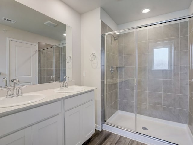 1850 Settlers Glen Dr Unit 502, Round Rock, TX 78665 - full bathroom featuring a stall shower, double vanity, and wood finished floors