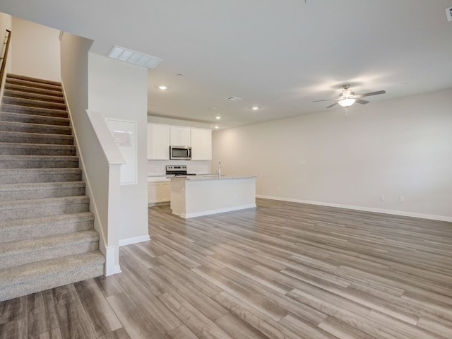 1850 Settlers Glen Dr Unit 502, Round Rock, TX 78665 - unfurnished living room with ceiling fan, light wood finished floors, stairway, baseboards, and recessed lighting