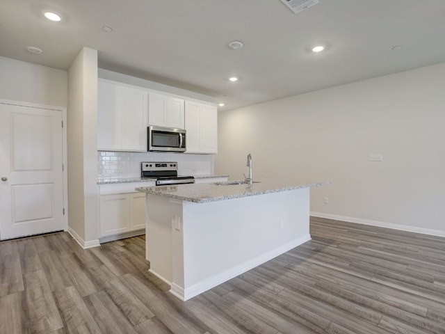 1850 Settlers Glen Dr Unit 502, Round Rock, TX 78665 - kitchen featuring stainless steel appliances, a sink, light wood finished floors, a center island with sink, and recessed lighting