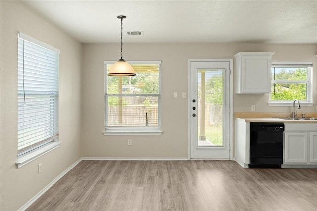 15411 Ora Ln, Pflugerville, TX 78660 - kitchen featuring a sink, black dishwasher, light wood-style floors, and white cabinetry