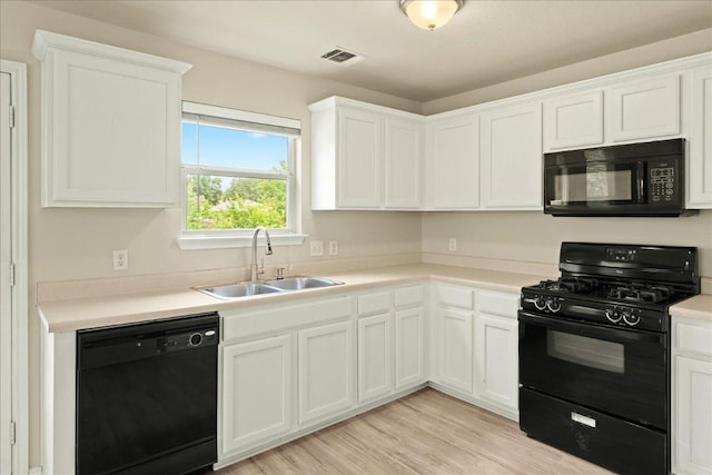 15411 Ora Ln, Pflugerville, TX 78660 - kitchen with black appliances, a sink, white cabinetry, light countertops, and light wood-type flooring