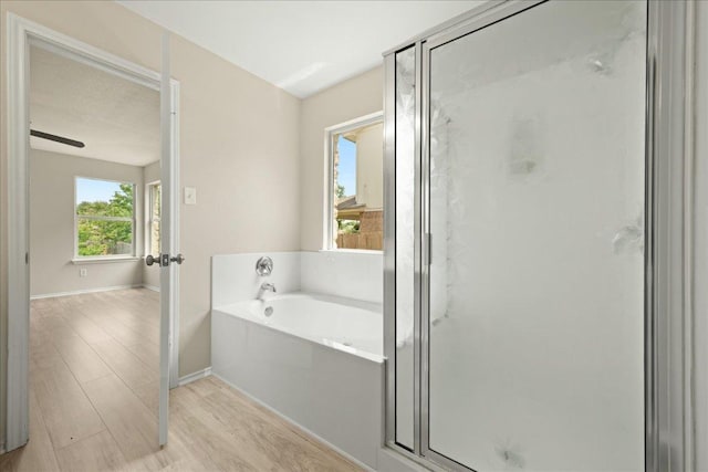 15411 Ora Ln, Pflugerville, TX 78660 - bathroom with a bath, a shower stall, and wood finished floors