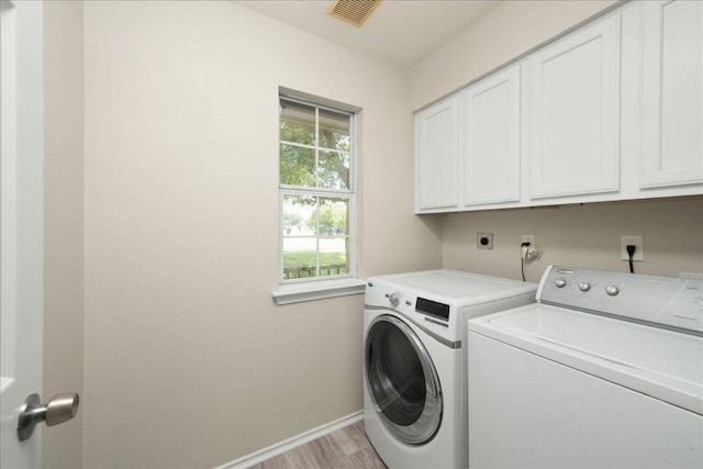 15411 Ora Ln, Pflugerville, TX 78660 - washroom featuring cabinet space, baseboards, separate washer and dryer, and light wood finished floors