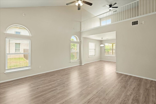 15411 Ora Ln, Pflugerville, TX 78660 - unfurnished living room featuring a ceiling fan, wood finished floors, high vaulted ceiling, and baseboards