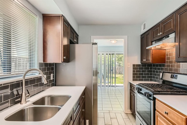 8524 Dryfield Dr, Austin, TX 78758 - kitchen with appliances with stainless steel finishes, under cabinet range hood, a sink, and light countertops