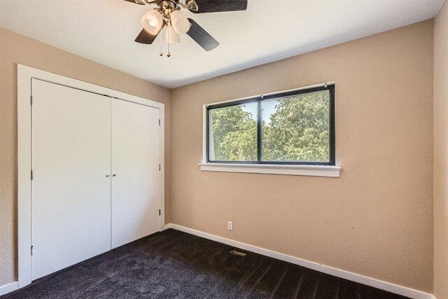 8524 Dryfield Dr, Austin, TX 78758 - unfurnished bedroom with dark colored carpet, a closet, baseboards, and a ceiling fan