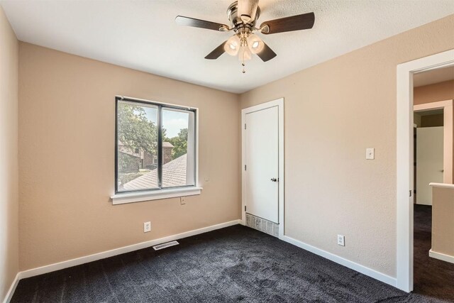 8524 Dryfield Dr, Austin, TX 78758 - unfurnished bedroom with dark colored carpet, baseboards, and a ceiling fan