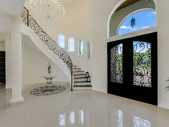 1001 Marly Way, Austin, TX 78733 - foyer featuring a towering ceiling, stairway, tile patterned flooring, baseboards, and a chandelier