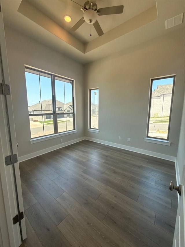 1101 Blanket Flower Dr, Georgetown, TX 78628 - unfurnished room with a raised ceiling, baseboards, a ceiling fan, and dark wood-type flooring