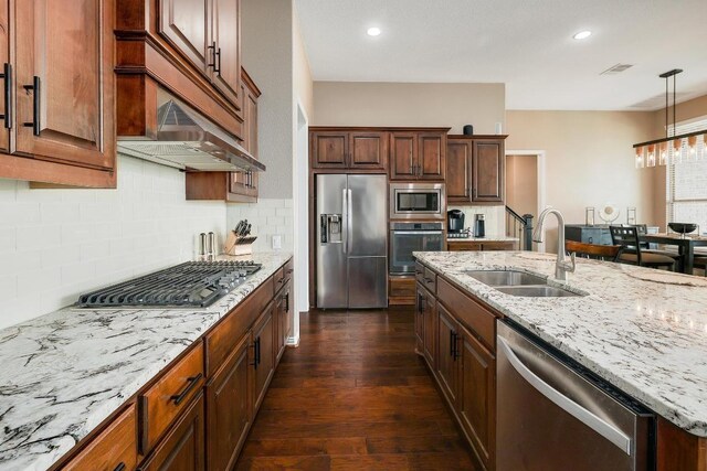 22218 W Cape Travis Bnd, Lago Vista, TX 78645 - kitchen featuring stainless steel appliances, a sink, dark wood-type flooring, tasteful backsplash, and decorative light fixtures