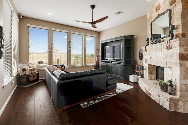 22218 W Cape Travis Bnd, Lago Vista, TX 78645 - living area featuring a ceiling fan, a stone fireplace, dark wood-style flooring, and baseboards