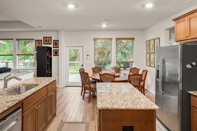 805 Willow Creek Cir, San Marcos, TX 78666 - kitchen featuring stainless steel appliances, a sink, light wood-type flooring, light stone countertops, and recessed lighting
