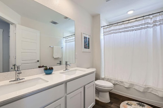 13908 Neskar Dr, Pflugerville, TX 78660 - full bath with wood finished floors, toilet, double vanity, and shower / bathtub combination with curtain