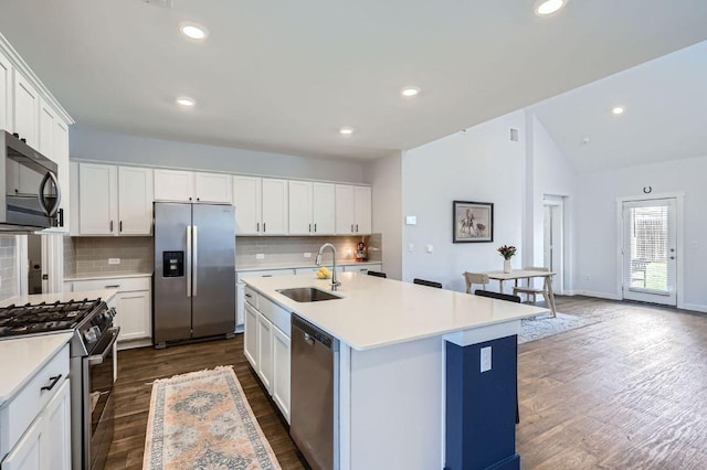 13908 Neskar Dr, Pflugerville, TX 78660 - kitchen with appliances with stainless steel finishes, a sink, dark wood-style flooring, tasteful backsplash, and lofted ceiling