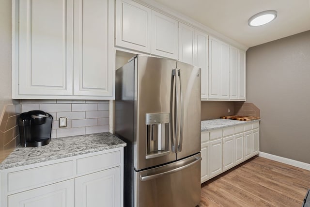 212 Lakefront Dr, Point Venture, TX 78645 - kitchen featuring stainless steel fridge, decorative backsplash, white cabinets, and light wood-style floors