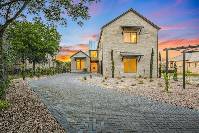 98 Wennmohs Pl, Horseshoe Bay, TX 78657 - modern home with stone siding, a standing seam roof, decorative driveway, and metal roof